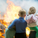 Family mother with children at burning house background
